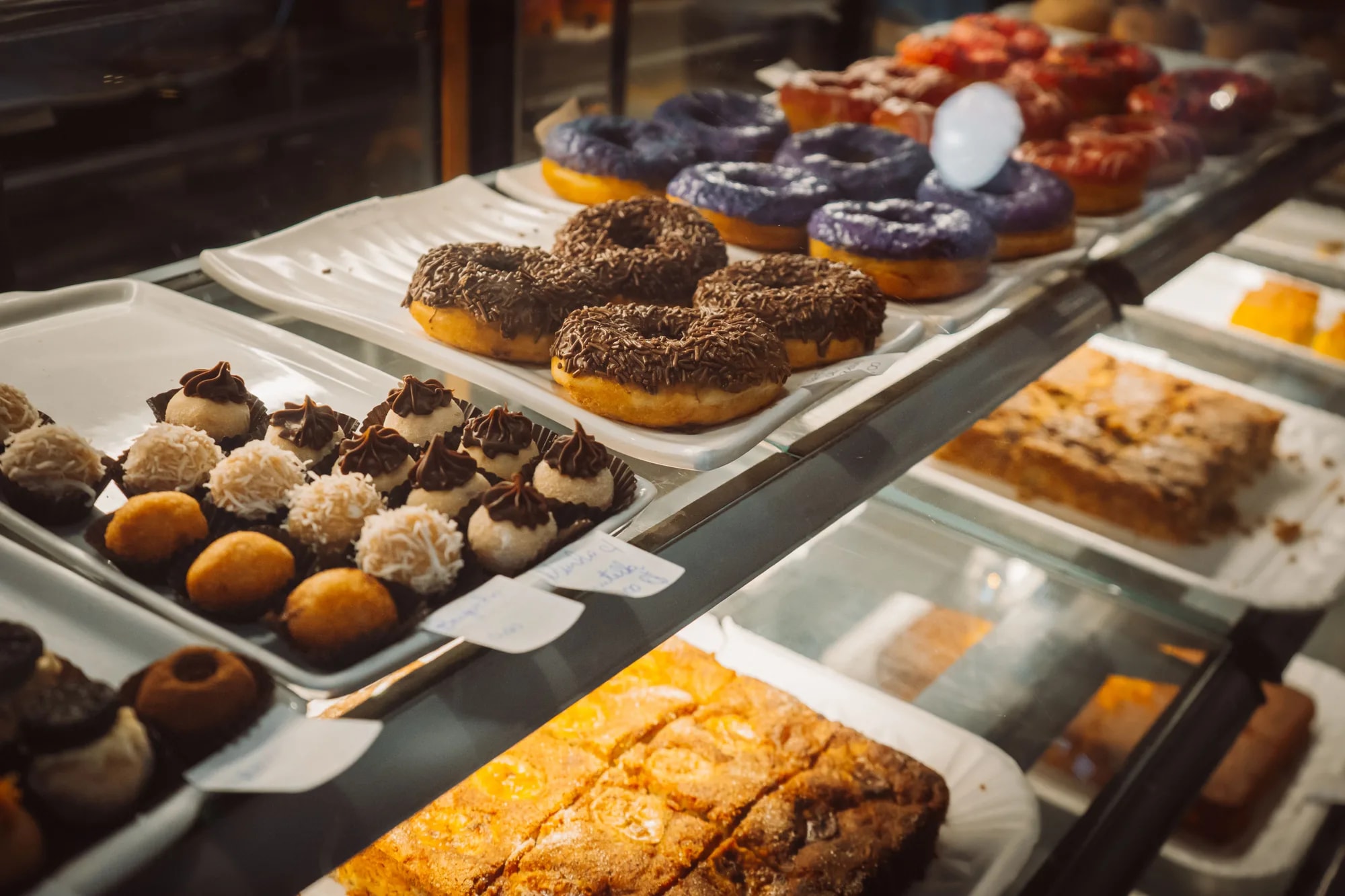 An assortment of colorful donuts and pastries arranged in a bakery display case