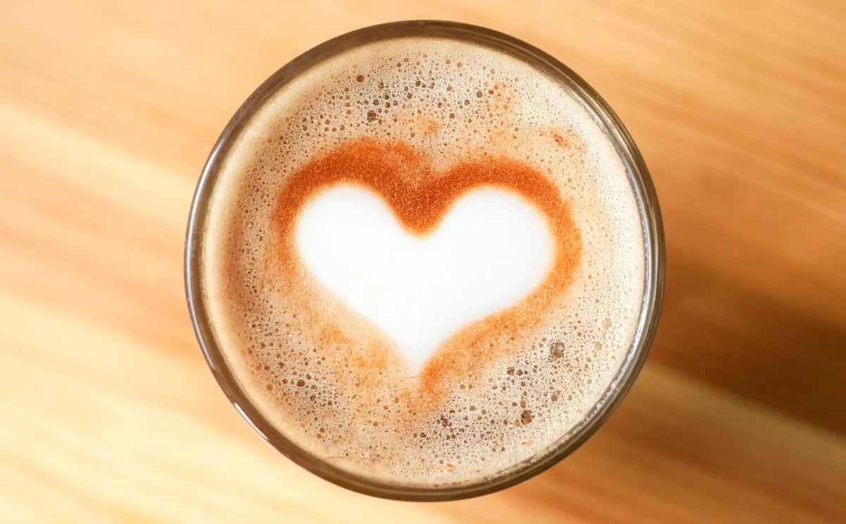 Close-up top-down view of a cappuccino with a heart shape crafted in the milk foam