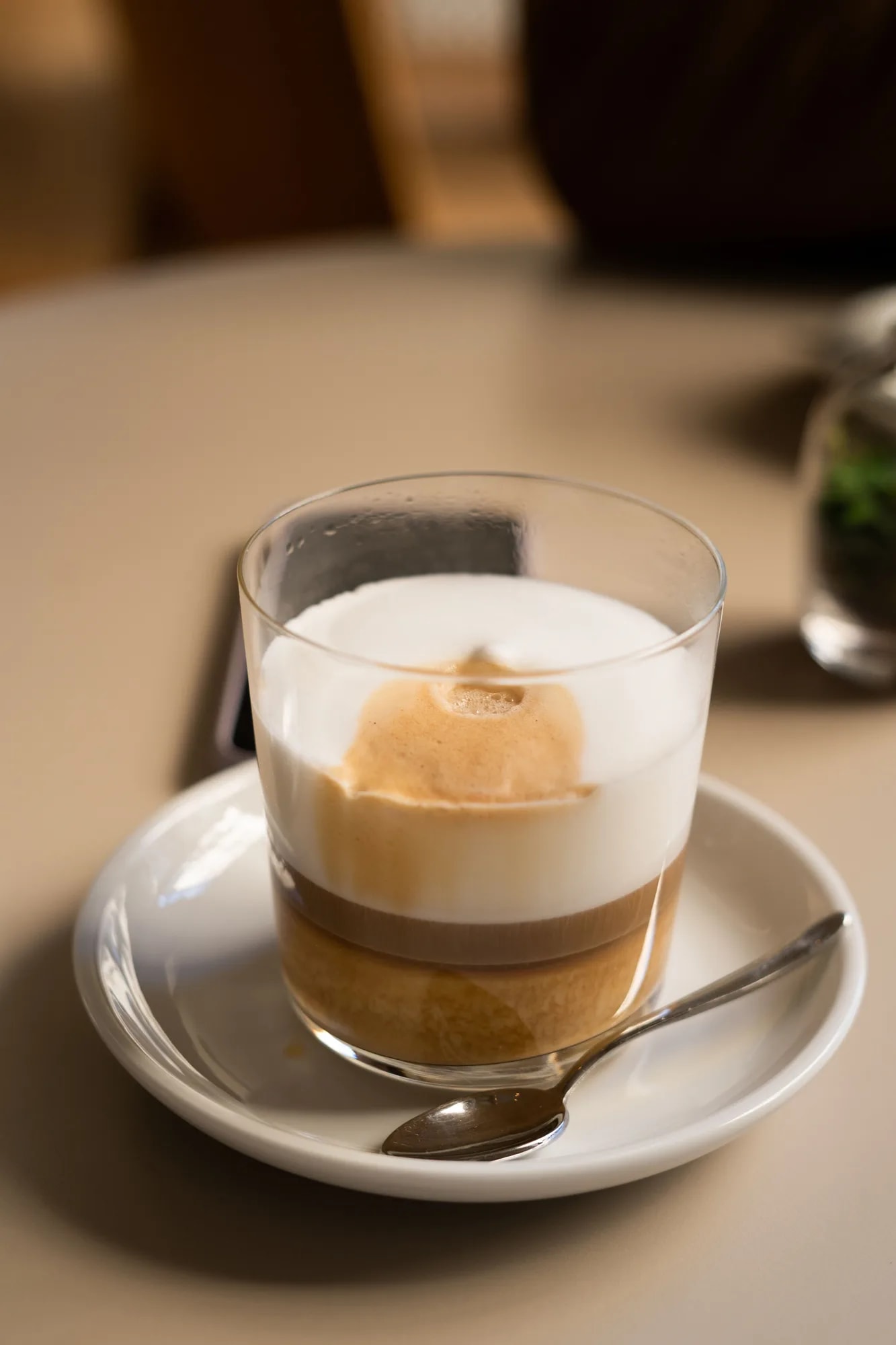 Close-up of a short espresso macchiato showing layered coffee and milk foam