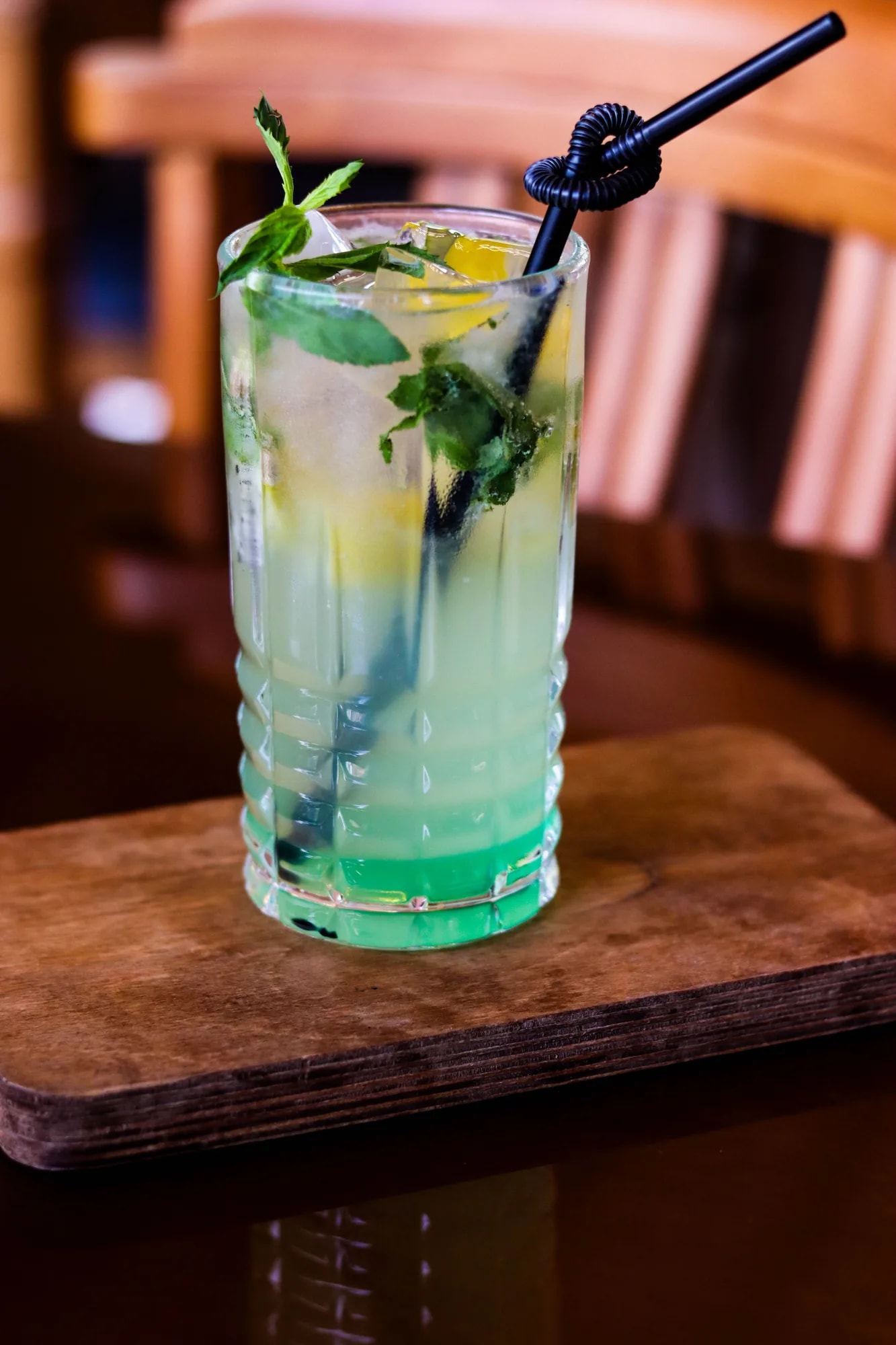 A virgin mojito mocktail with fresh mint and lime in a tall glass with a straw