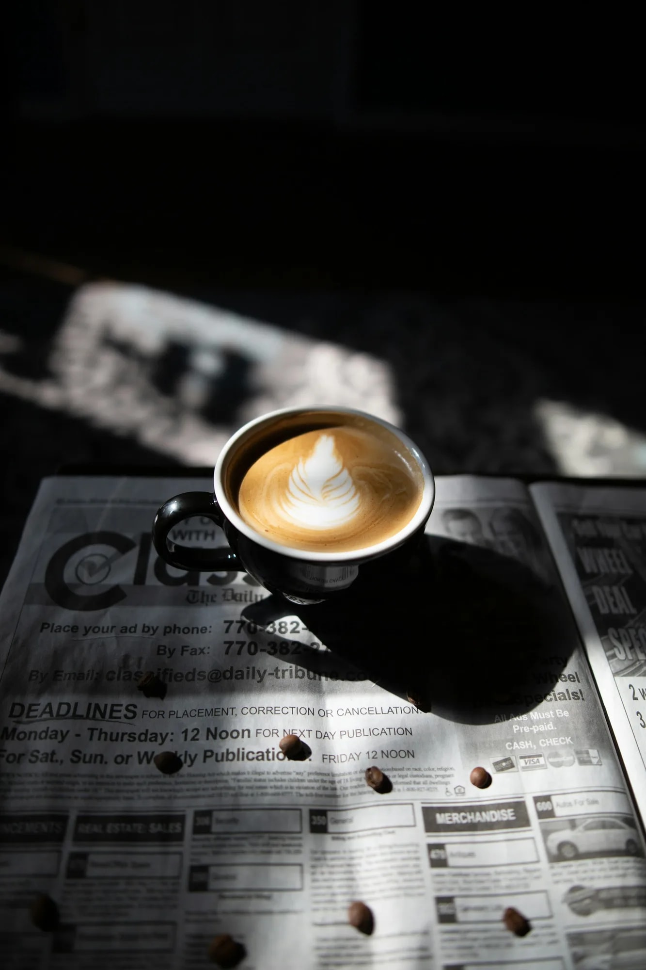 Close-up of intricate latte art in a dark ceramic cup