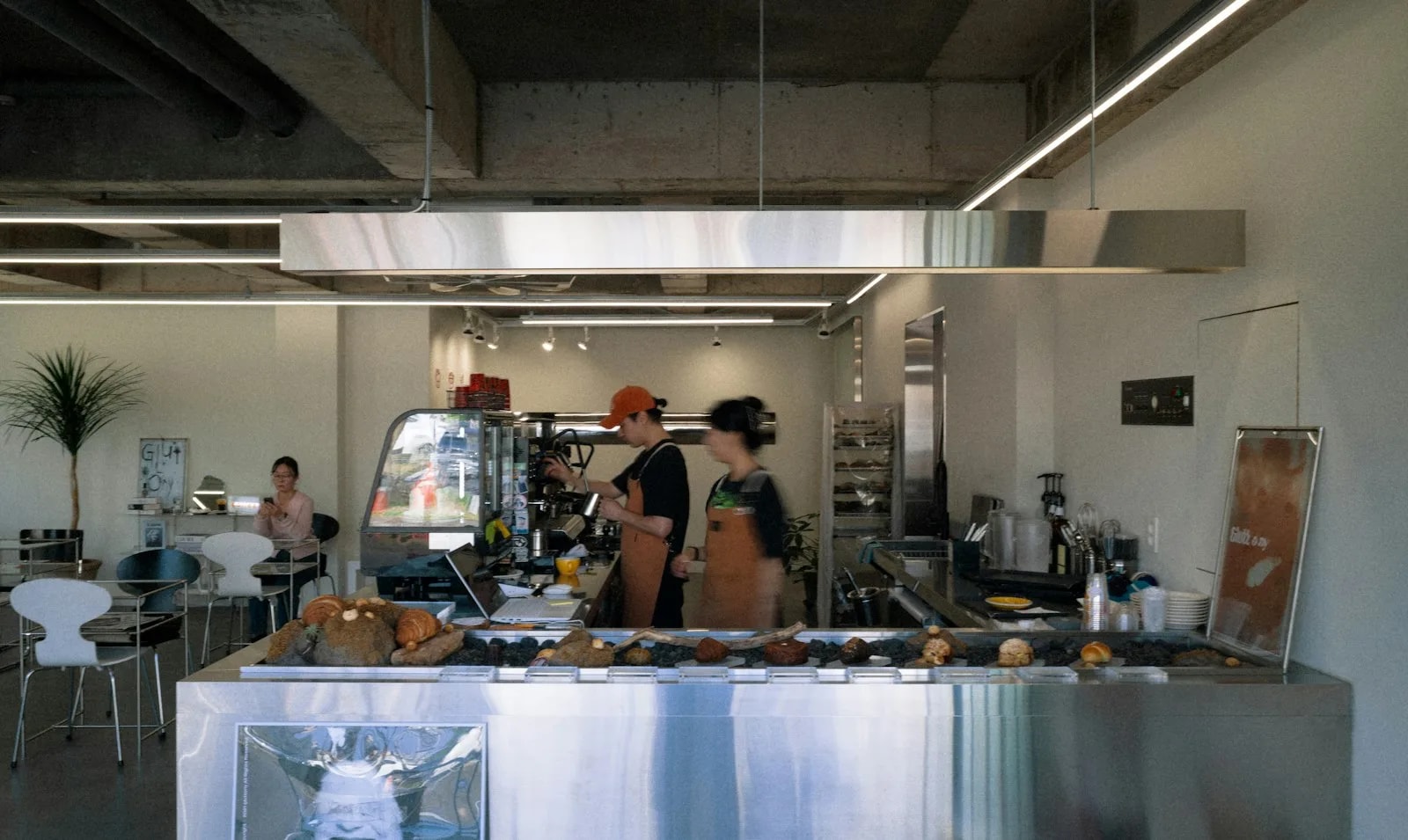 Baristas preparing drinks behind a modern coffee shop counter, evoking B2B café supply