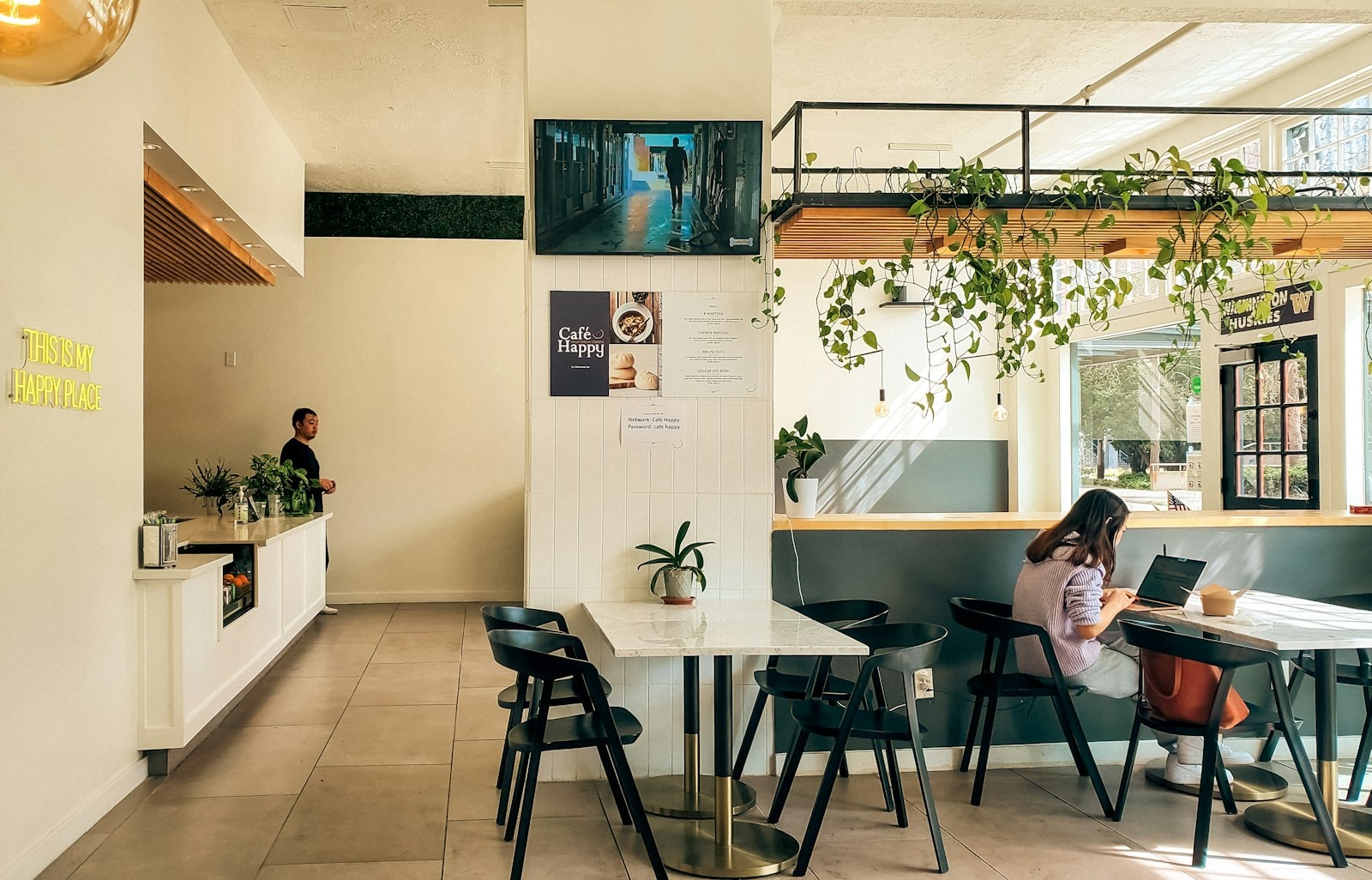 Modern cafe interior with patrons working and relaxing at a coffee shop counter